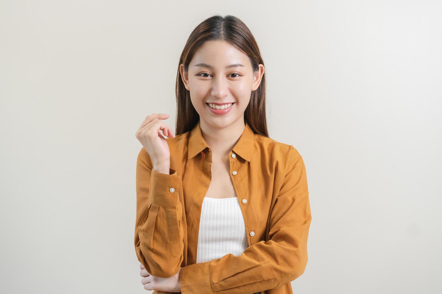 souriant positif, attrayant asiatique Jeune femme portant décontractée robe, portrait de magnifique brunette sa avec longue marron cheveux, sentiment content à la recherche à caméra permanent isolé sur blanc Contexte. photo