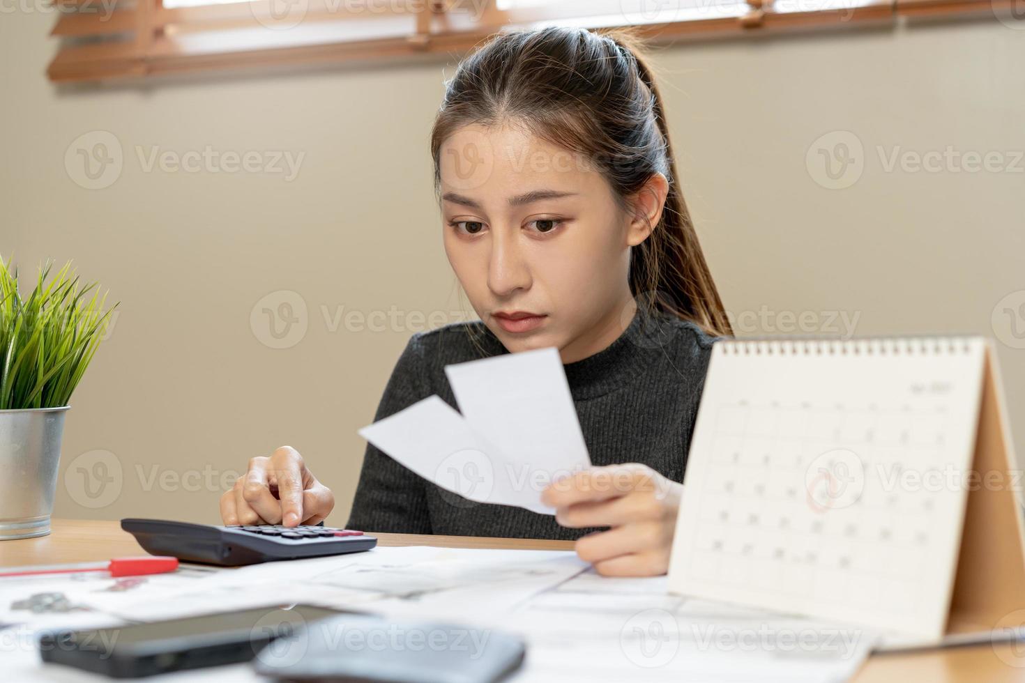 financier devoir asiatique femme, femelle séance sur sol maison, stressé et confus par calculer frais de facture d'achat ou facture, avoir non argent à payer, hypothèque ou prêt. dette, la faillite ou faillite concept. photo