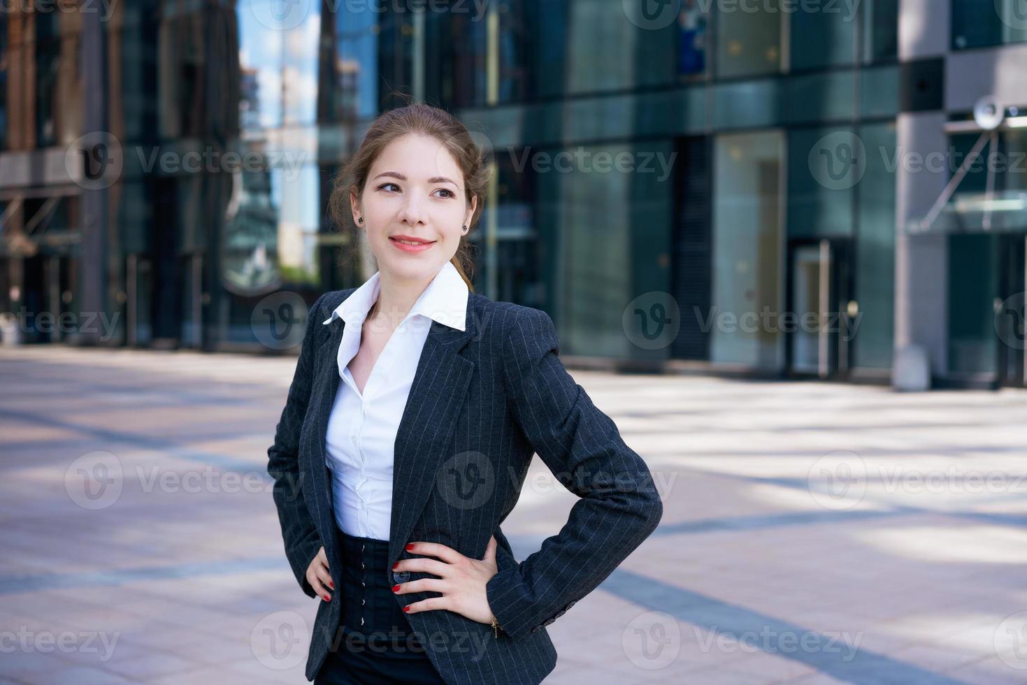 affaires femme dans costume les usages téléphone intelligent. gros ville avec grattes ciels dans Contexte. parlant sur le téléphone pendant le journée photo