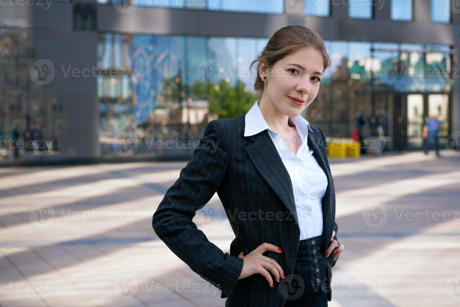 affaires femme dans costume les usages téléphone intelligent. gros ville avec grattes ciels dans Contexte. parlant sur le téléphone pendant le journée photo