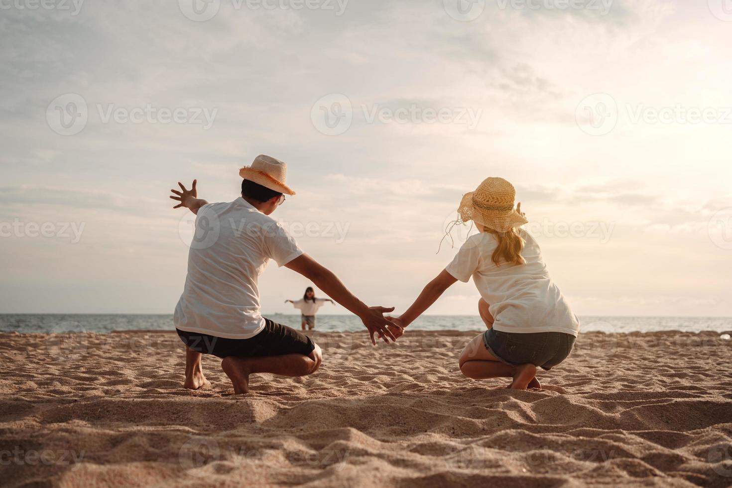 content asiatique famille prendre plaisir le mer plage à qui consiste père, mère et fille ayant amusement en jouant plage dans été vacances sur le océan plage. content famille avec les vacances temps mode de vie concept. photo