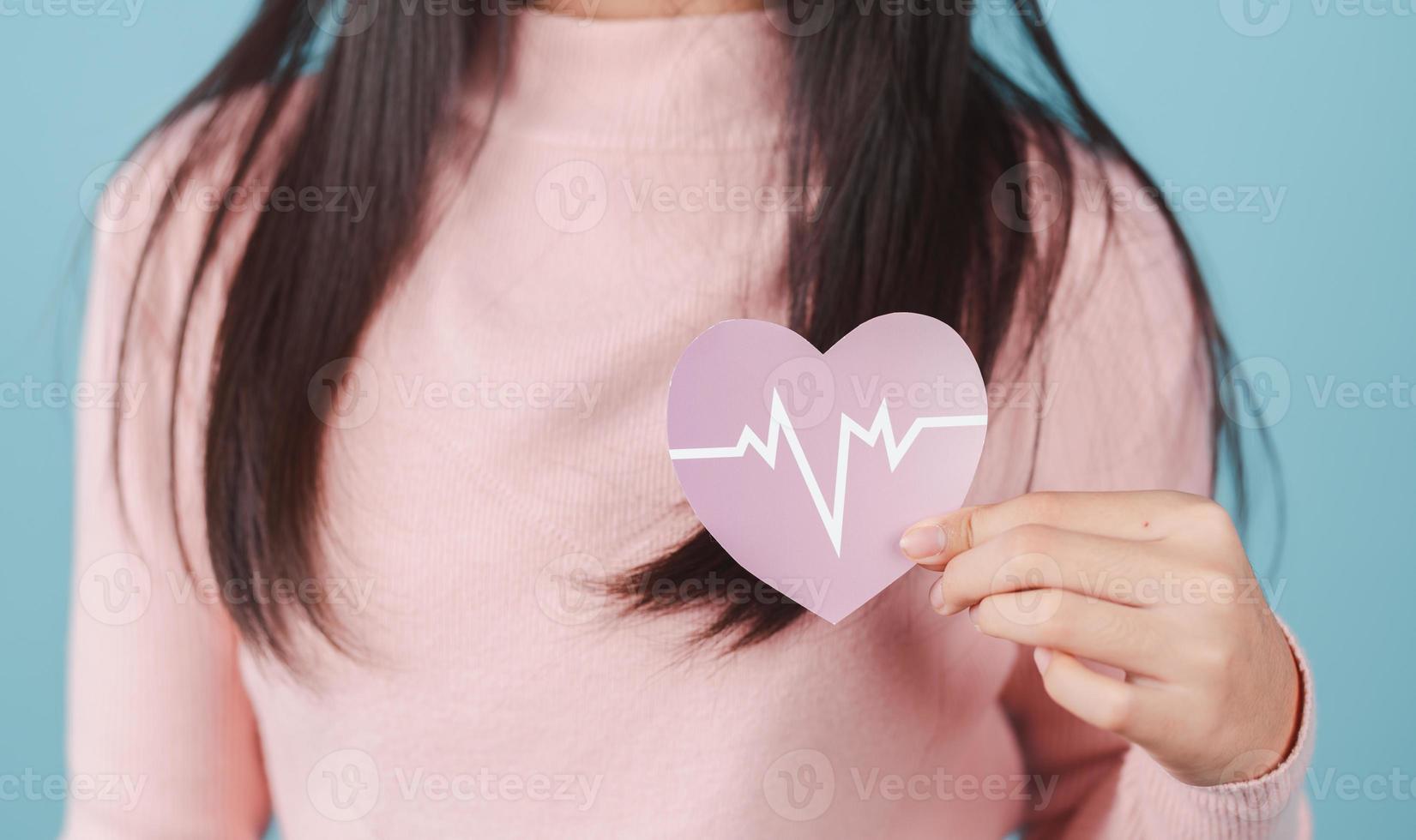 femme en portant cœur anatomie papier couper, cœur attaque, cœur maladie, femelle avec santé se soucier et en bonne santé féminin, monde cœur journée concept. photo
