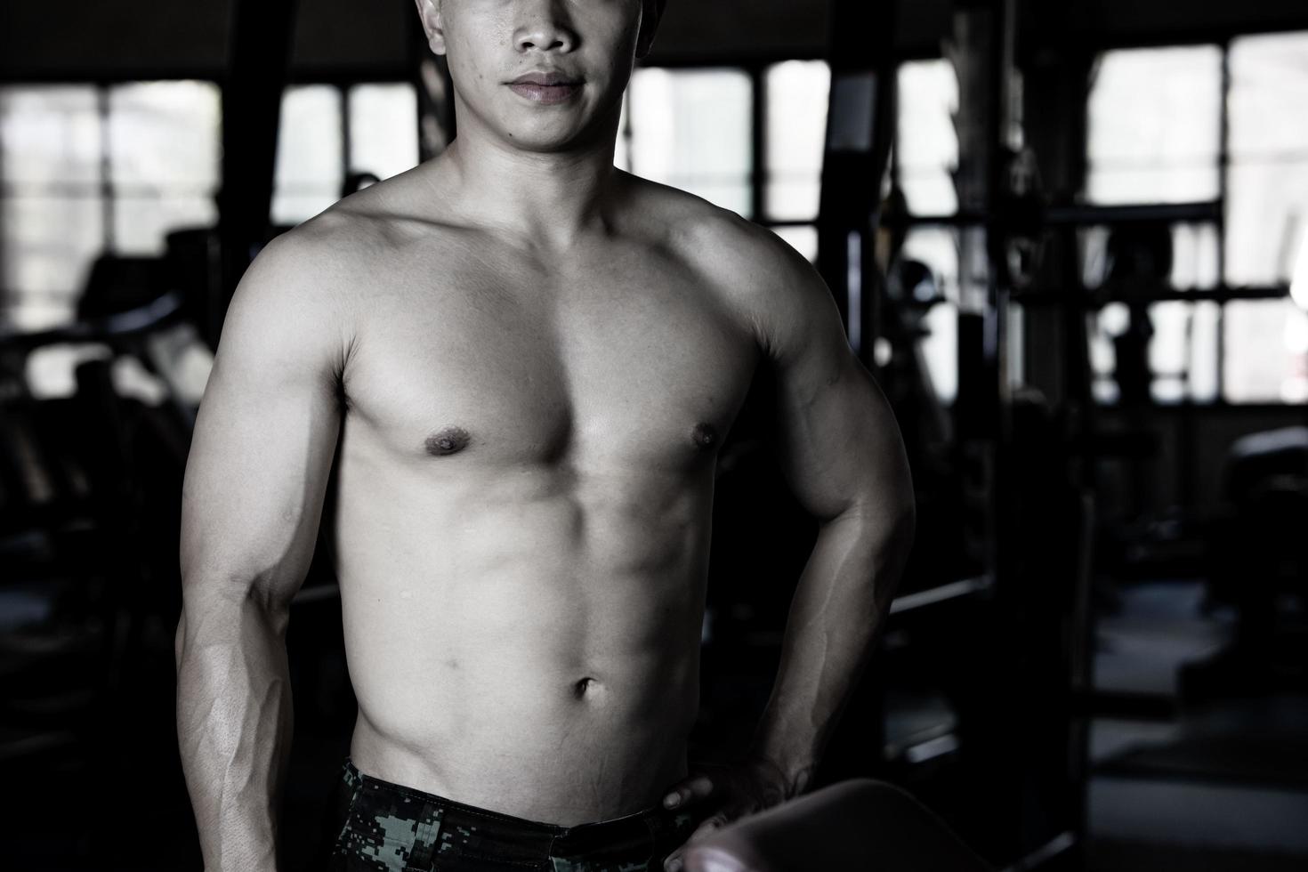 sexy corps de musclé Jeune soldat asiatique homme dans salle de sport. concept de santé se soucier, exercice aptitude, fort muscle masse, corps renforcement, graisse réduction pour Pour des hommes santé supplément produit présentation. photo