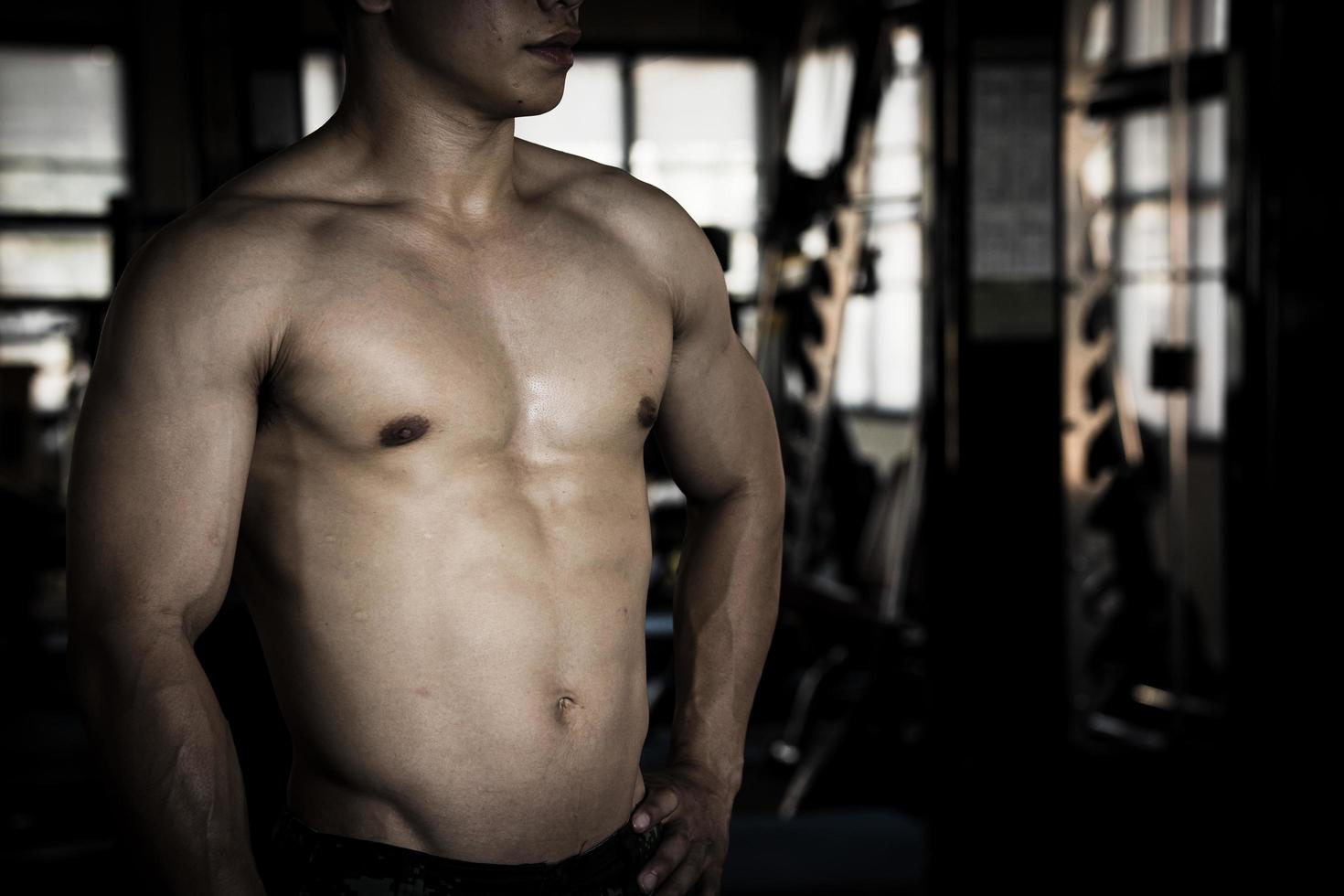 sexy corps de musclé Jeune soldat asiatique homme dans salle de sport. concept de santé se soucier, exercice aptitude, fort muscle masse, corps renforcement, graisse réduction pour Pour des hommes santé supplément produit présentation. photo