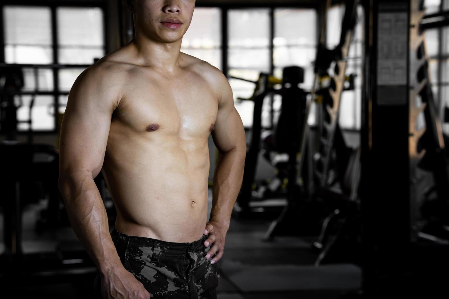 sexy corps de musclé Jeune soldat asiatique homme dans salle de sport. concept de santé se soucier, exercice aptitude, fort muscle masse, corps renforcement, graisse réduction pour Pour des hommes santé supplément produit présentation. photo