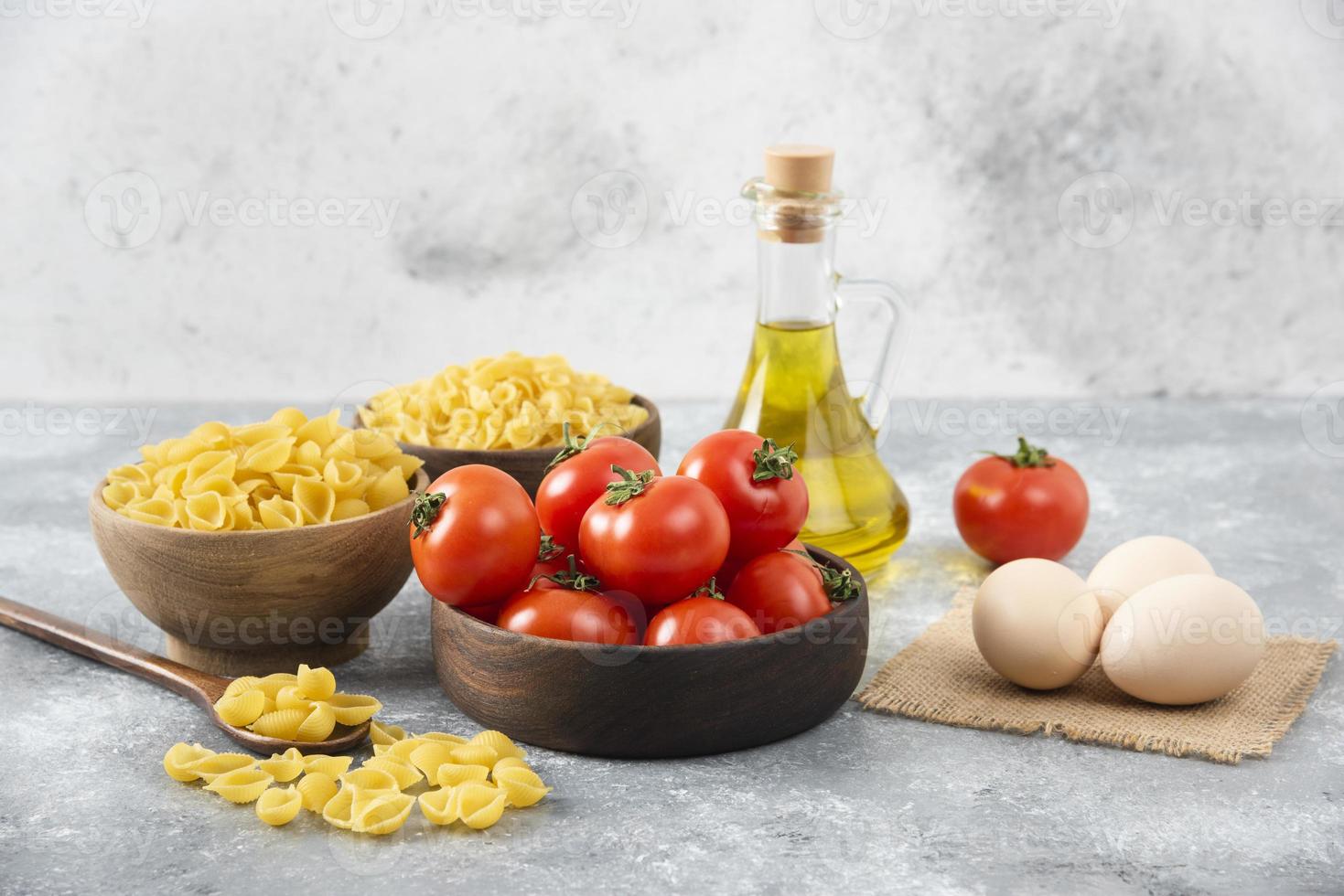 œufs de poule crus avec une bouteille en verre d'huile et de légumes frais photo