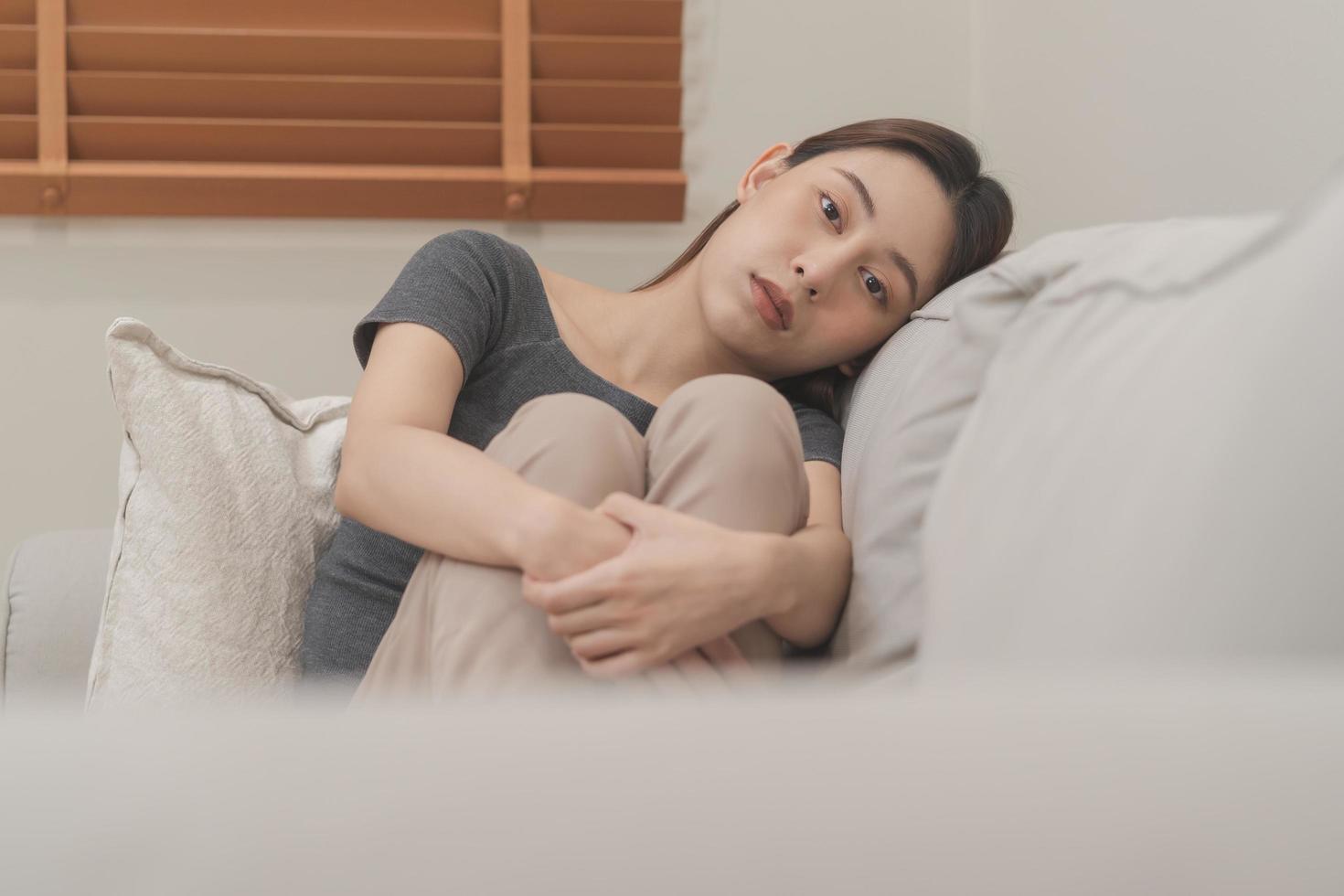 mental santé, déprimé triste asiatique Jeune femme, fille séance sur canapé, canapé, expression à visage difficulté, échec et épuisé. réfléchi inquiet Souffrance la dépression sentiment seul, seul à Accueil photo