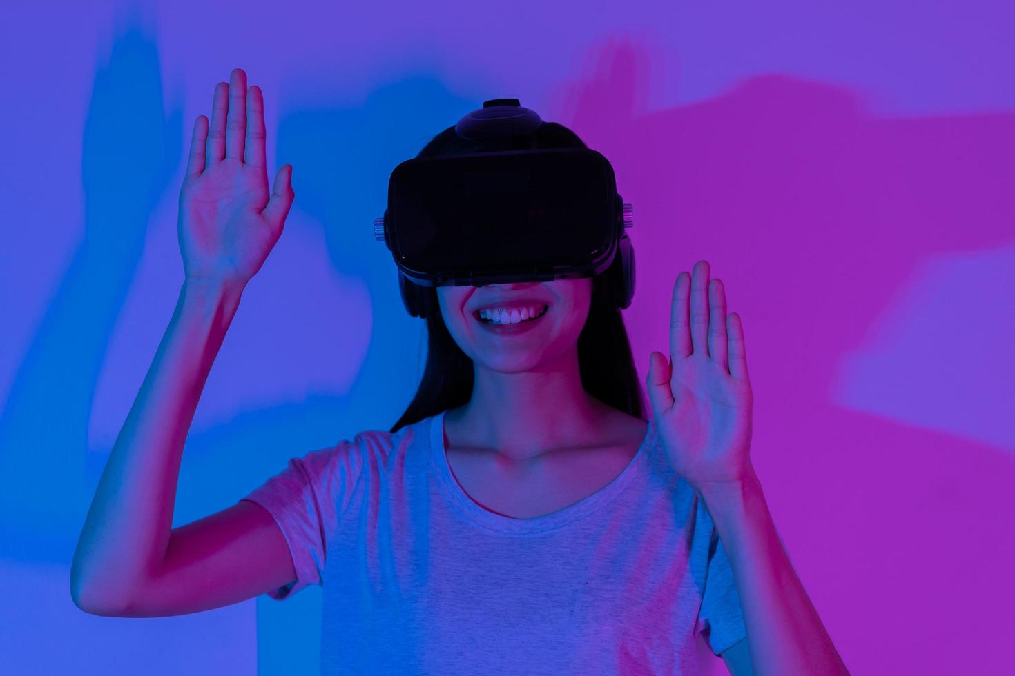 des loisirs, asiatique Jeune femme portant vr casque ou visuel réalité des lunettes de protection, des lunettes ou gadget, jouer vidéo Jeu de simulateur futur, futuriste tandis que portable, séance sur canapé, canapé. photo