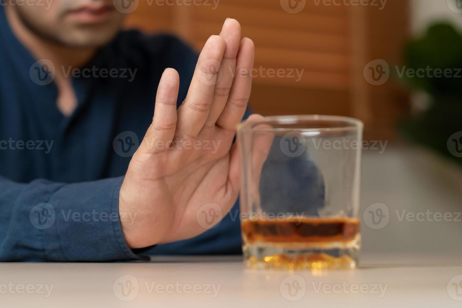 alcoolisme, déprimé asiatique Jeune homme refuser, pousser en dehors alcoolique boisson verre, boisson whisky, séance seul à nuit. traitement de de l'alcool dépendance, ayant souffrir abuser de problème alcoolisme concept. photo