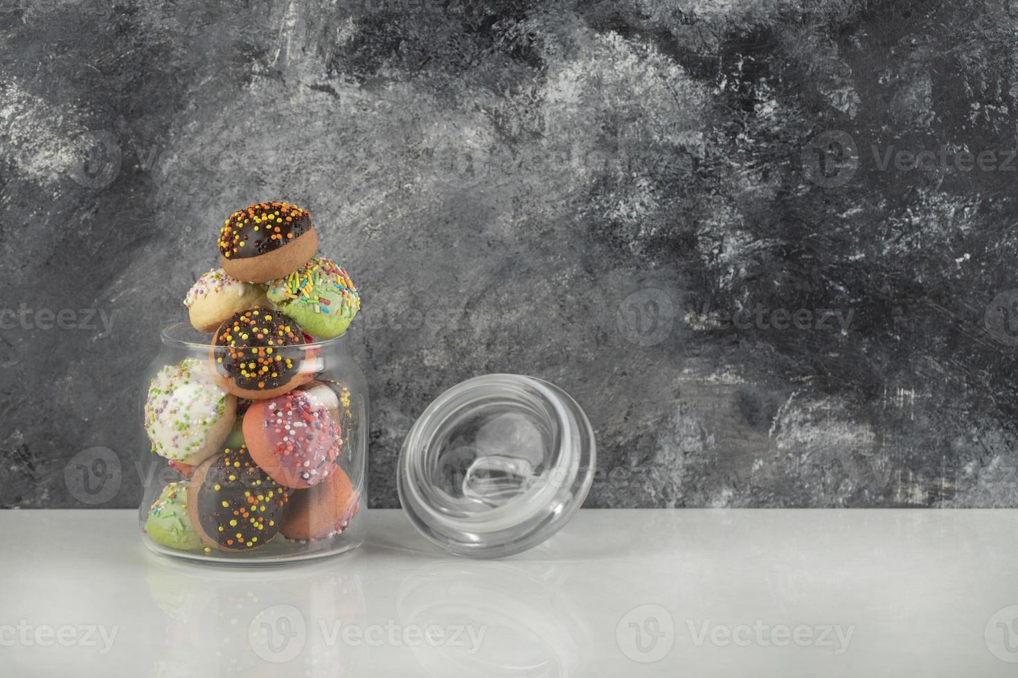 un bocal en verre rempli de petits beignets colorés photo