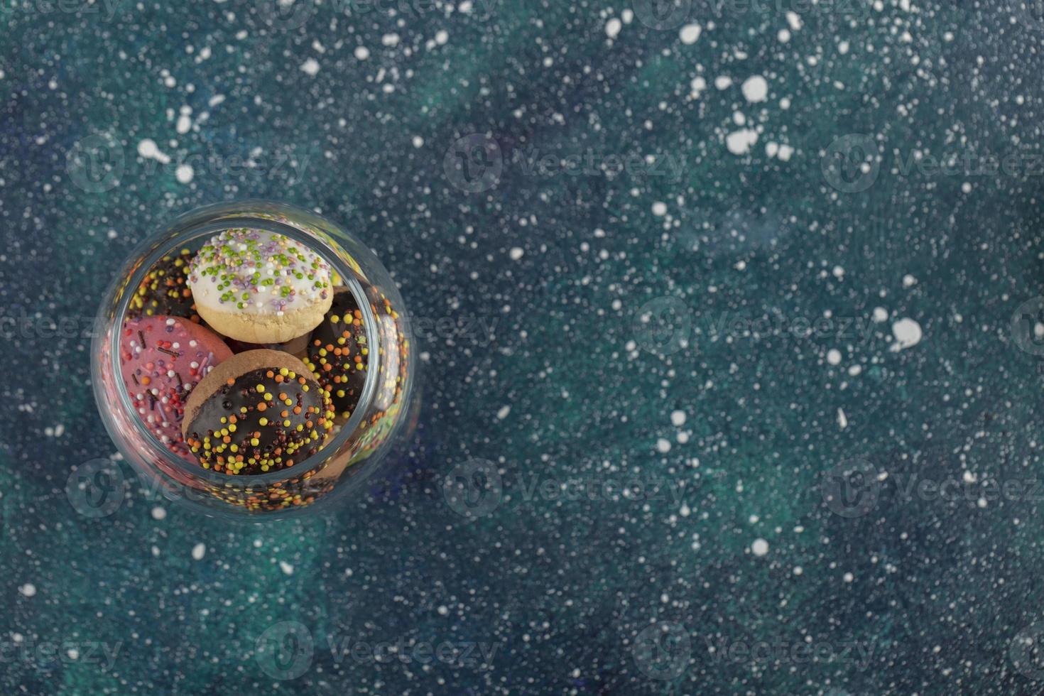 un bocal en verre rempli de petits beignets colorés photo