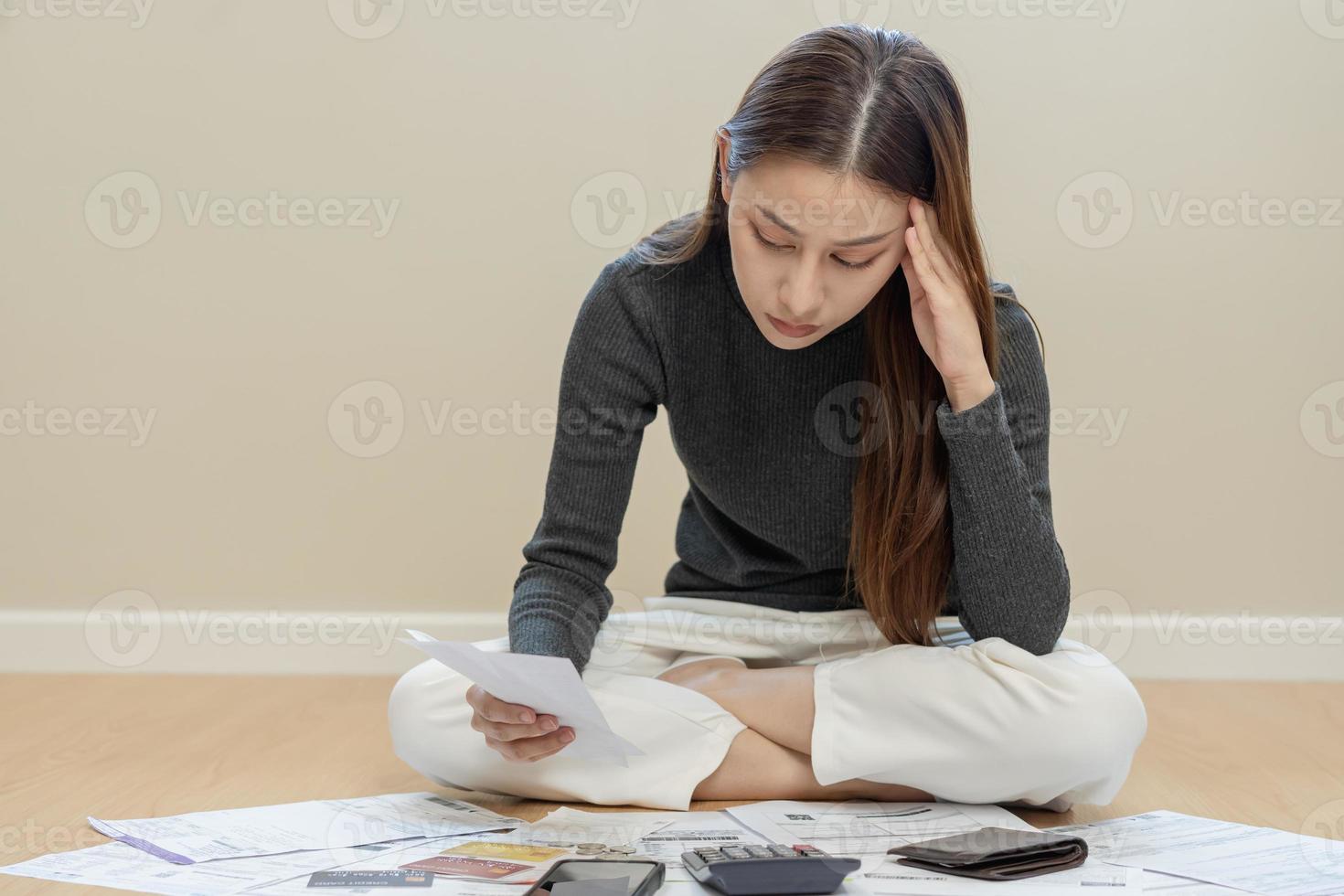 financier devoir asiatique femme, femelle séance sur sol maison, stressé et confus par calculer frais de facture d'achat ou facture, avoir non argent à payer, hypothèque ou prêt. dette, la faillite ou faillite concept. photo