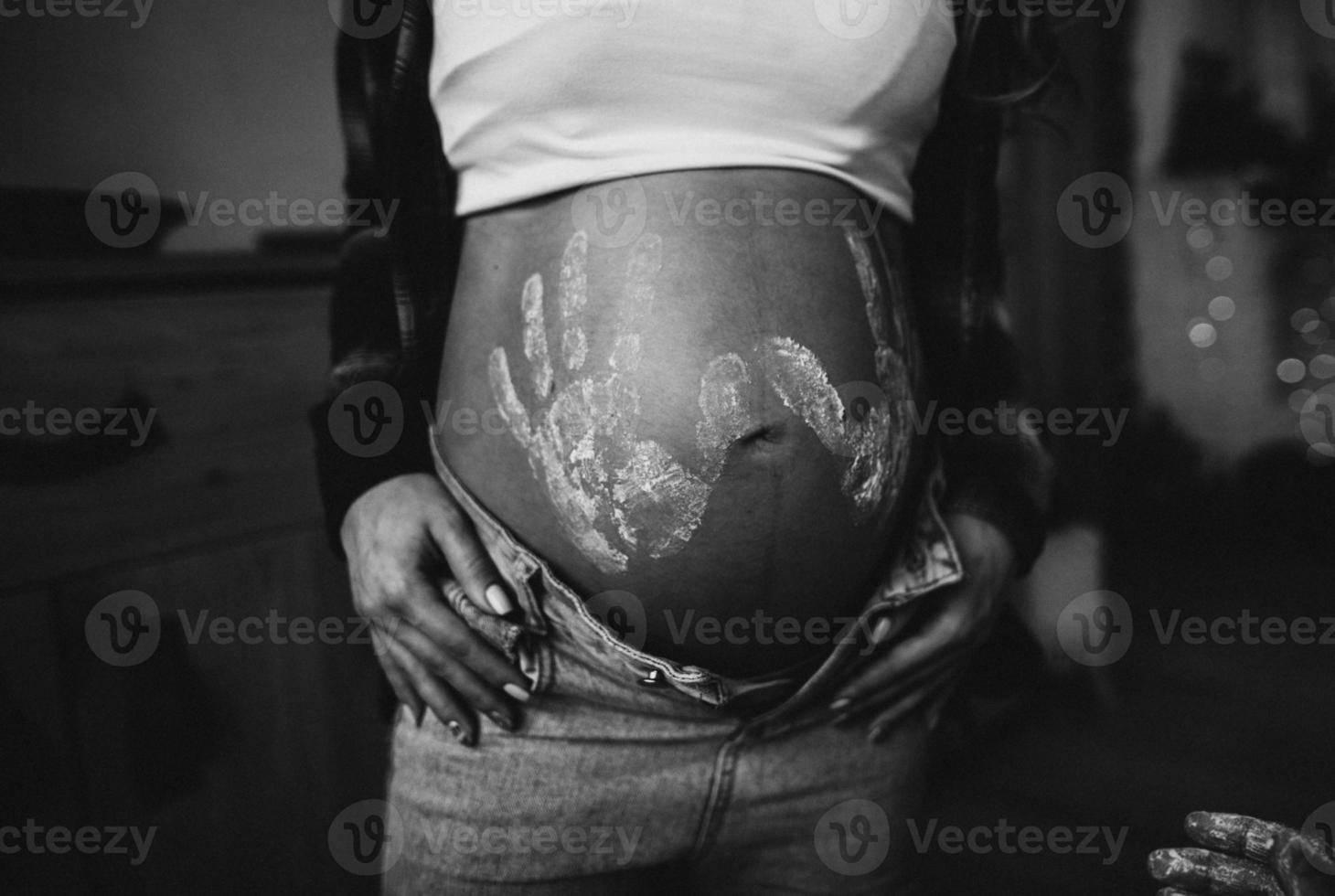 femme Enceinte ventre avec enfant impressions dans chemise et bleu jeans photo