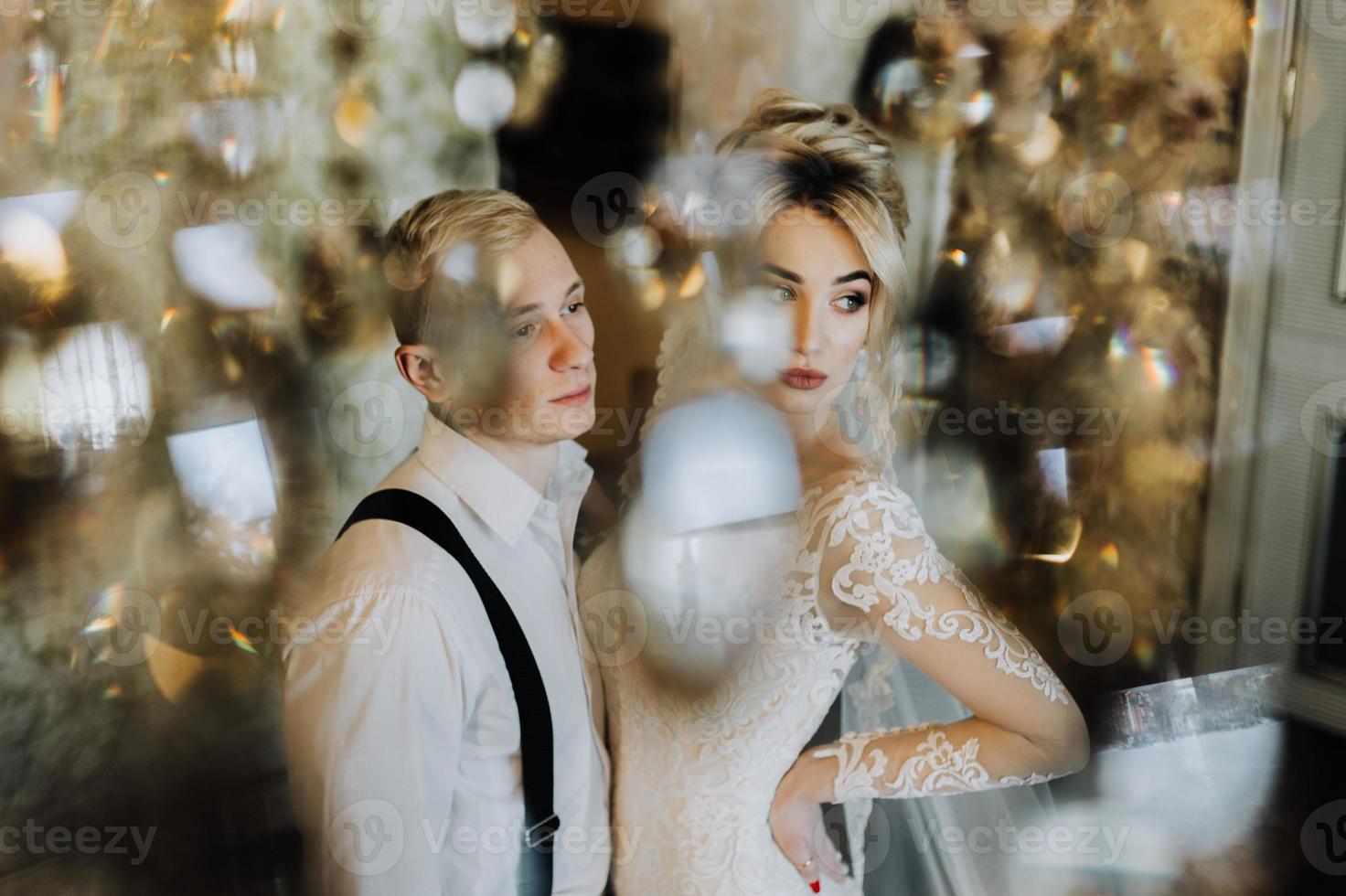 le charmant couple embrasser dans le hôtels hall près le lustre photo