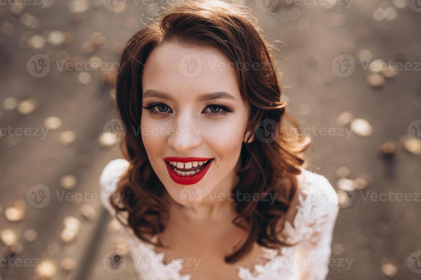 Extérieur mode portrait de charme Dame avec parfait maquillage et embrasé peau, pleine rouge lèvres, et gros yeux posant à coucher de soleil, bronzage modèle face.sexy parfait en forme corps femme.attrayante sexy et Jeune fille photo