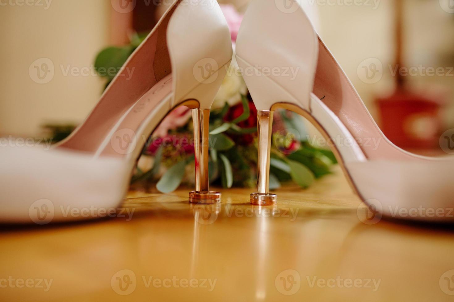 mariage anneaux mensonge sur blanc chaussures. photo