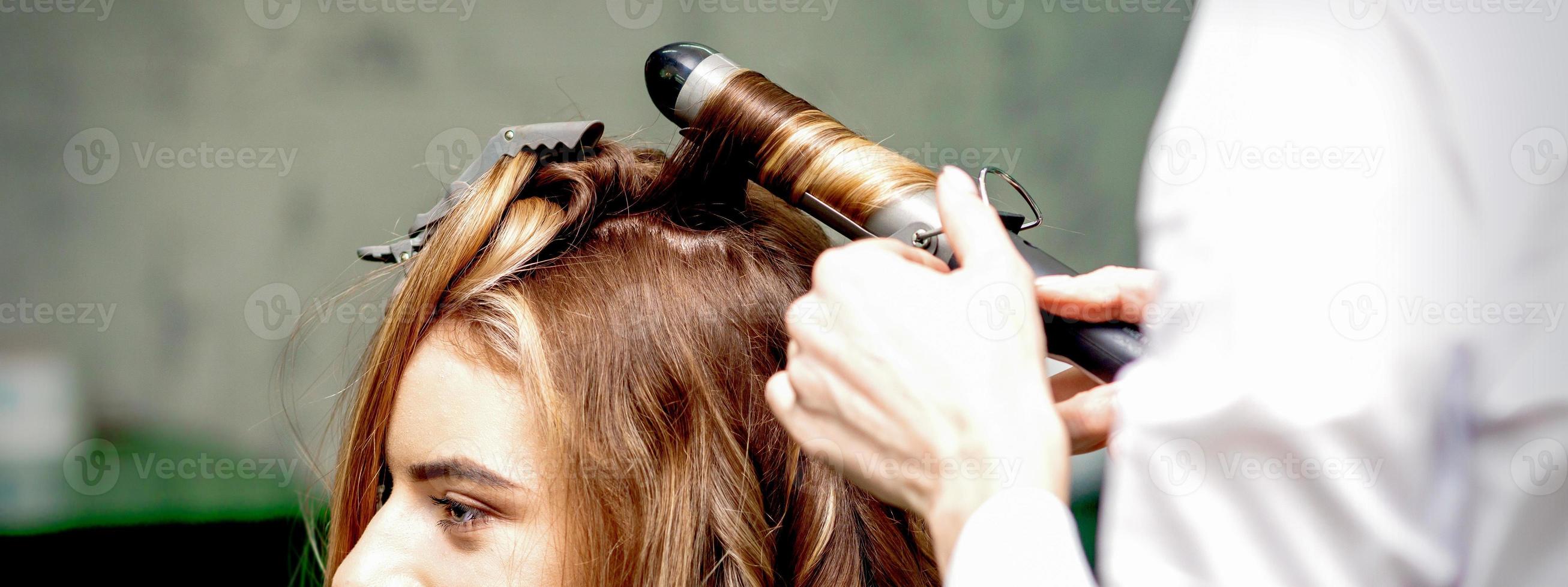 coiffeur fait du boucles avec curling le fer photo