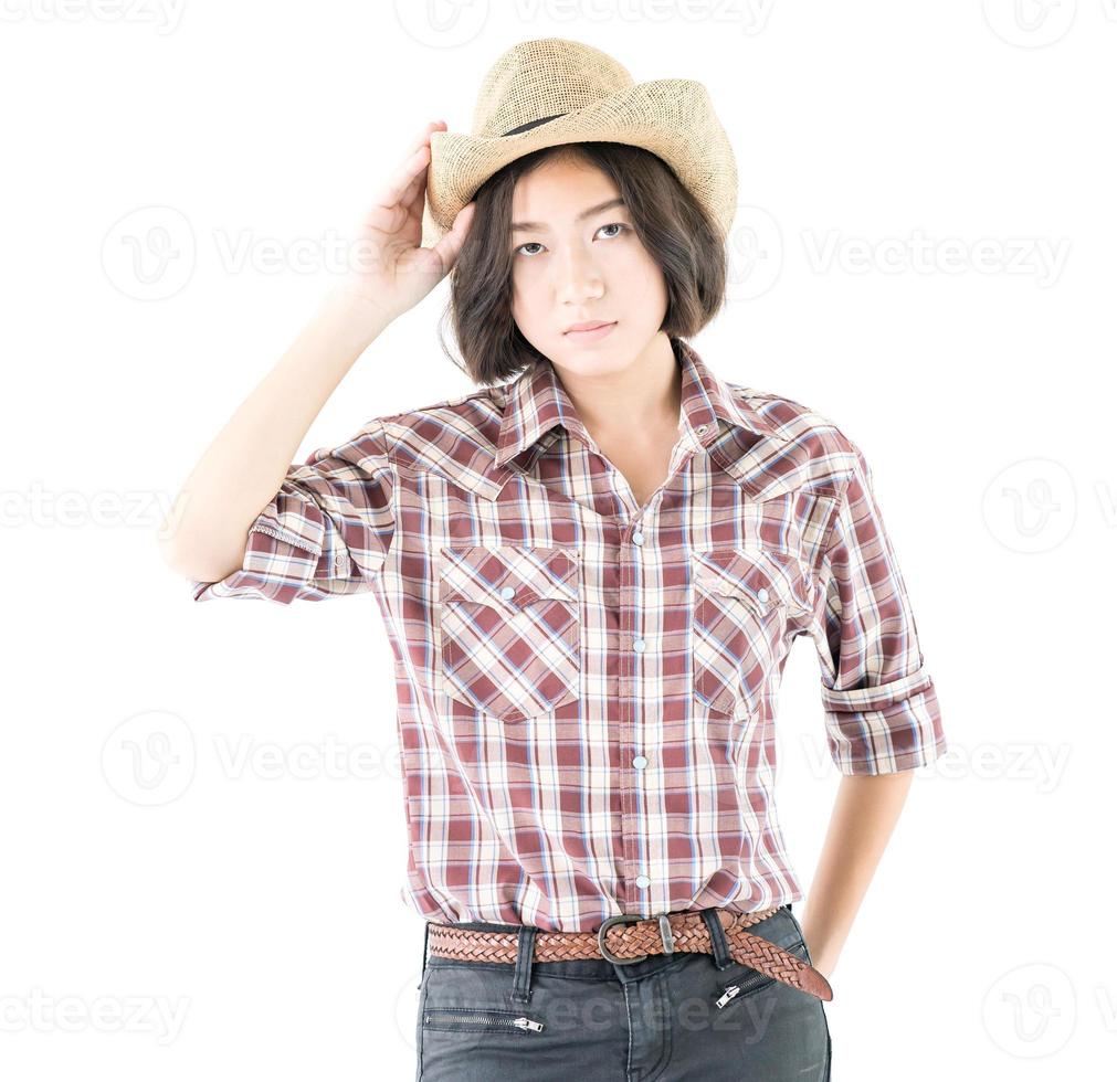 jeune femme dans un chapeau de cow-boy et une chemise à carreaux avec la main sur son chapeau photo