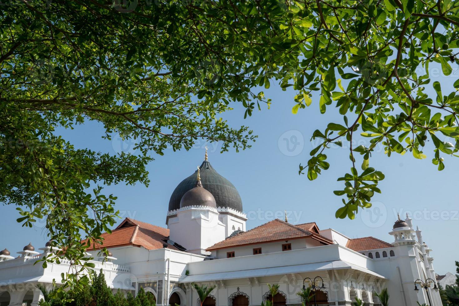 kapitan keling mosquée avec premier plan feuilles photo