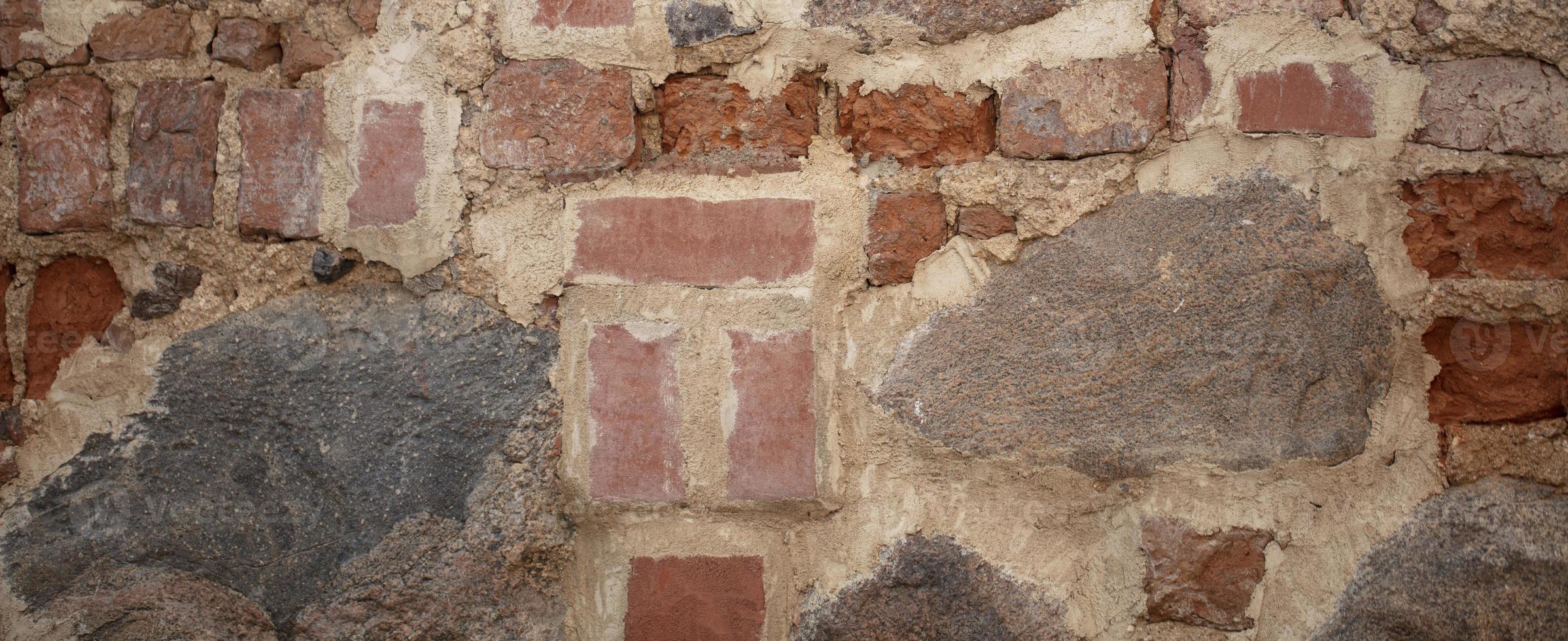 Contexte de un vieux mur fabriqué de pierre et rugueux brique. photo