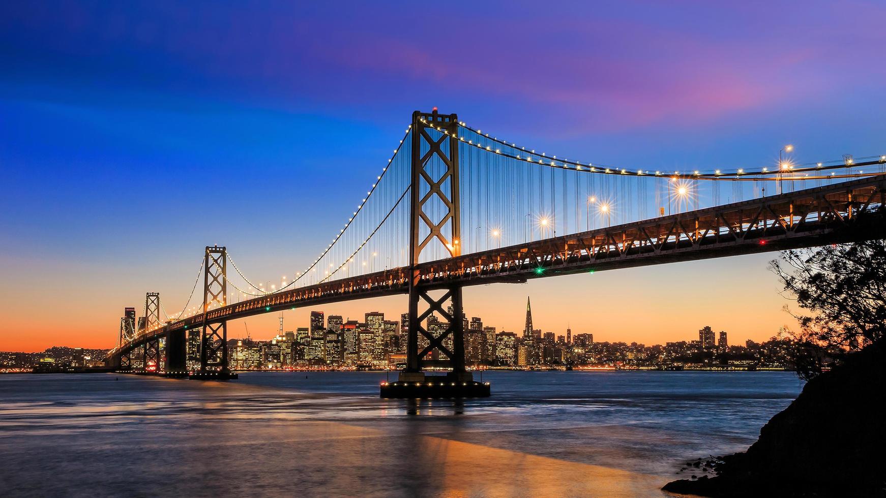 Skyline de San Francisco et Bay Bridge au coucher du soleil, Californie photo