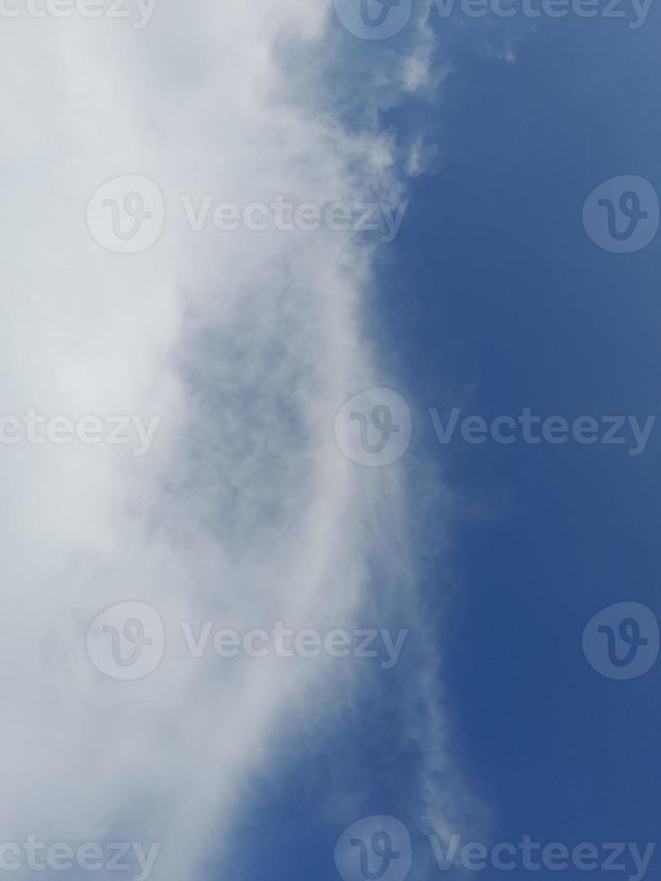 beaux nuages blancs sur fond de ciel bleu profond. de grands nuages doux et moelleux couvrent tout le ciel bleu. photo