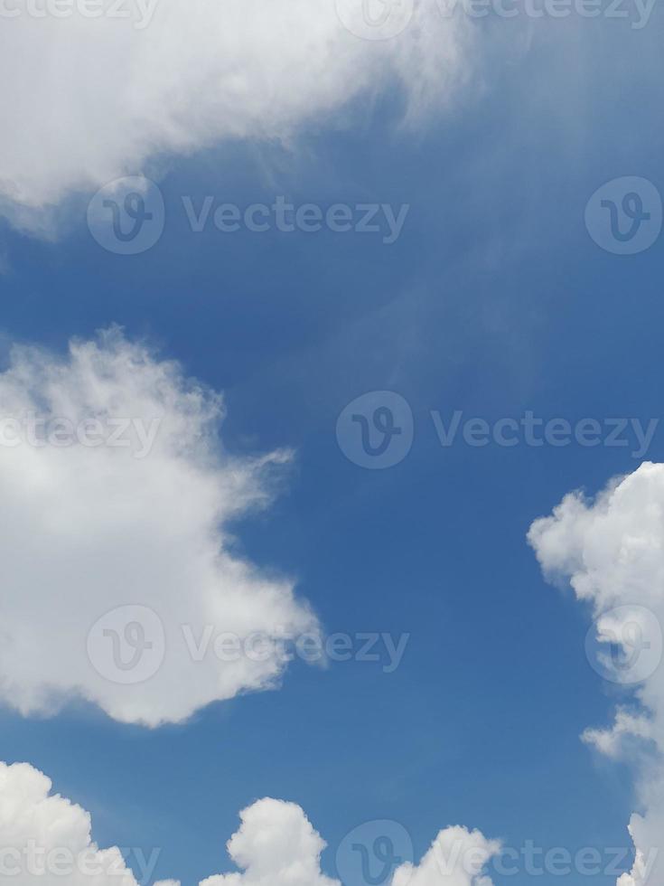 beaux nuages blancs sur fond de ciel bleu profond. de grands nuages doux et moelleux couvrent tout le ciel bleu. photo