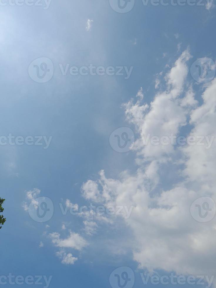 beaux nuages blancs sur fond de ciel bleu profond. de grands nuages doux et moelleux couvrent tout le ciel bleu. photo