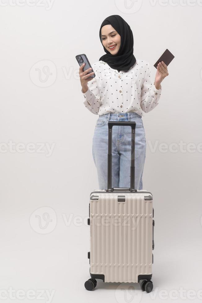 une Jeune musulman femme touristique avec bagages sur blanc Contexte photo