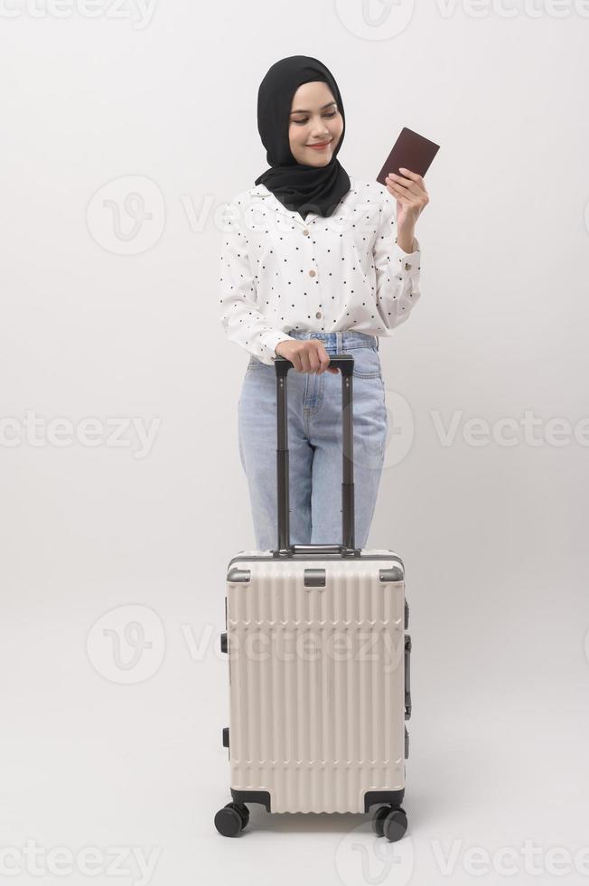 une Jeune musulman femme touristique avec bagages sur blanc Contexte photo