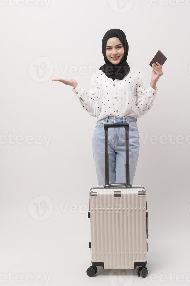 une Jeune musulman femme touristique avec bagages sur blanc Contexte photo