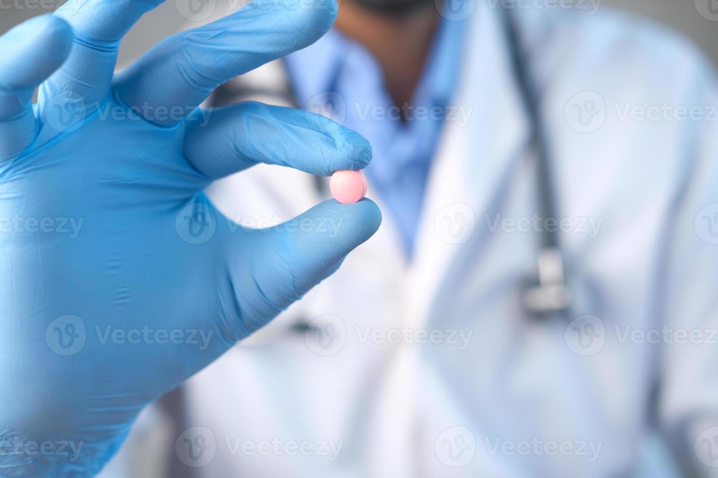 médecin tenant une pilule rose ronde photo