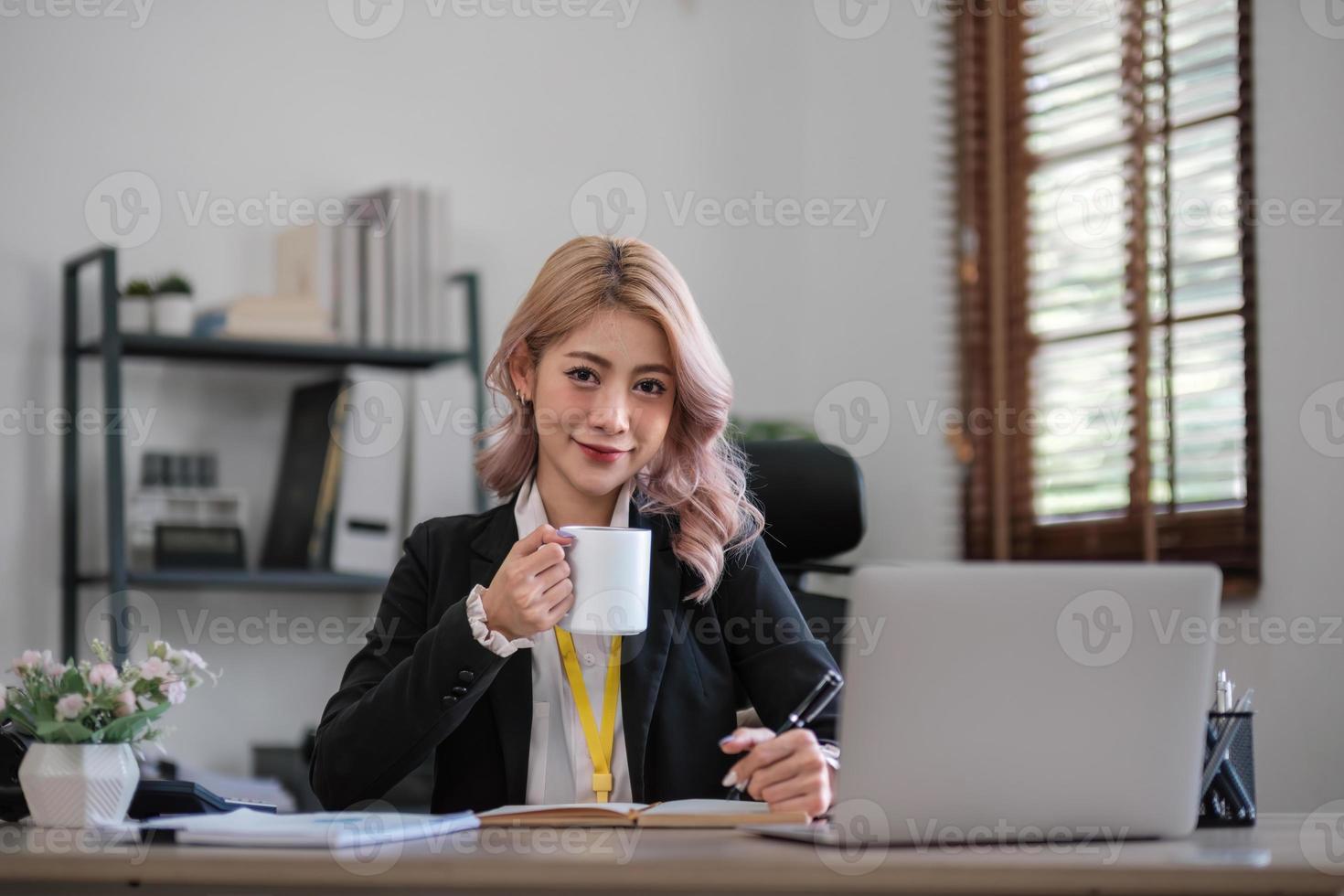 femme d'affaires utilisant une calculatrice pour faire de la finance mathématique sur un bureau en bois au bureau et dans les affaires fond de travail, fiscalité, comptabilité, statistiques et concept de recherche analytique photo