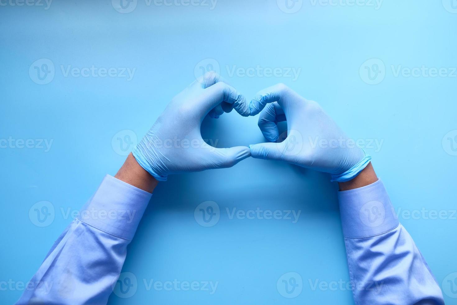 mains du médecin en forme de coeur sur fond bleu photo