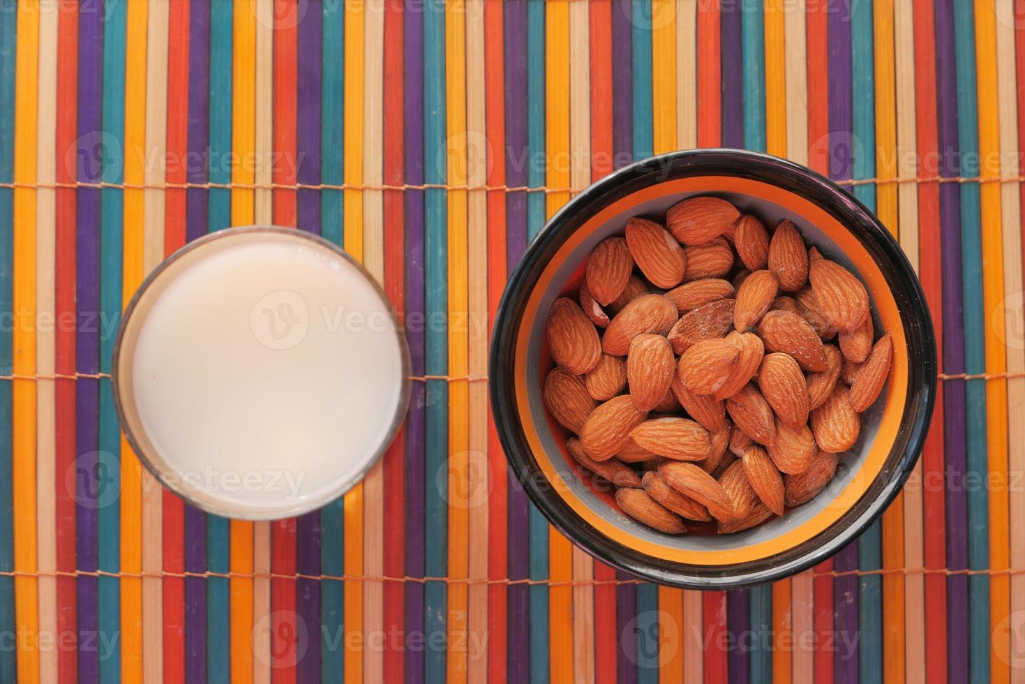 amandes et un verre de lait sur une nappe colorée photo