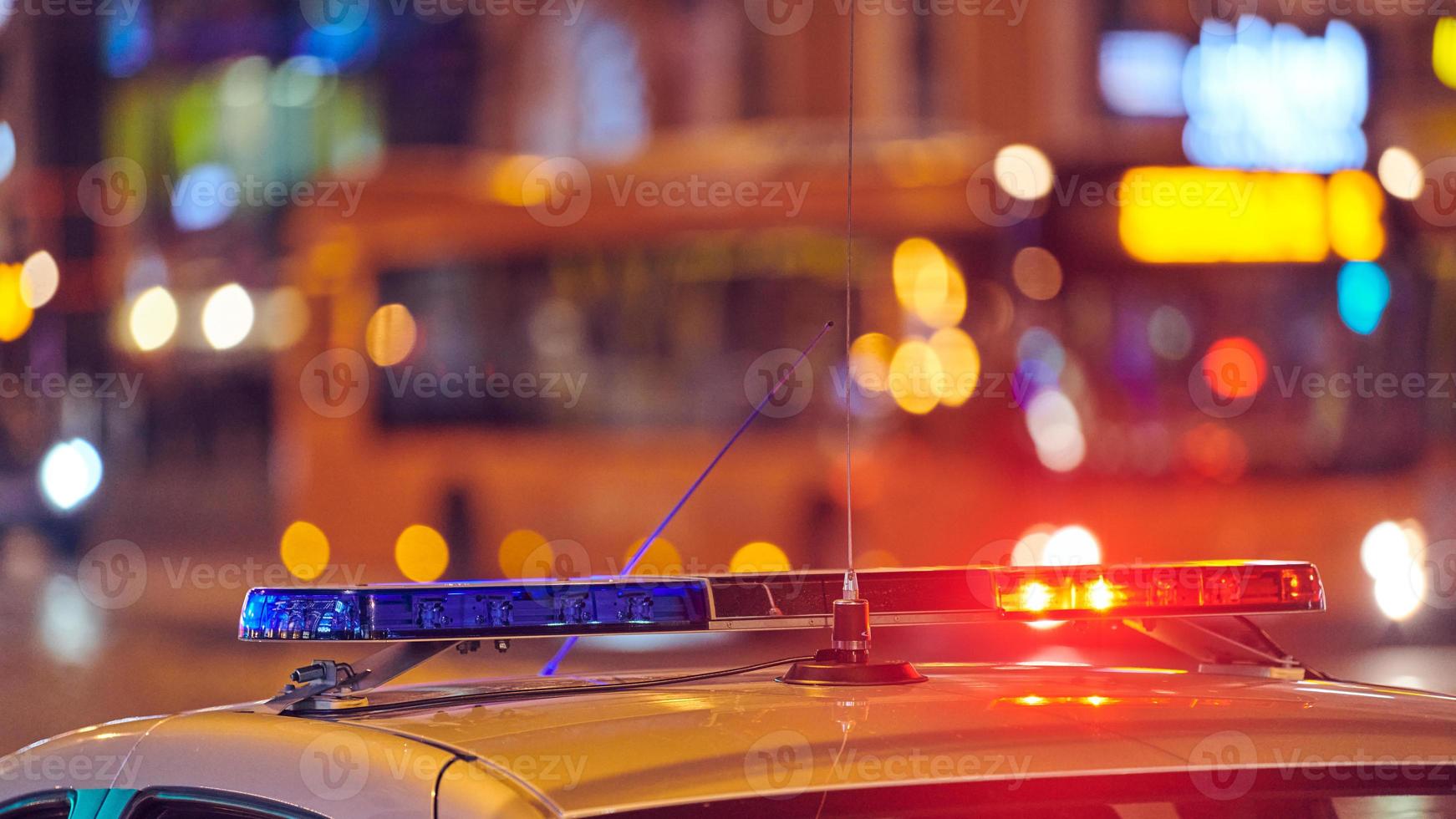 voiture de police s'allume la nuit rue de la ville photo