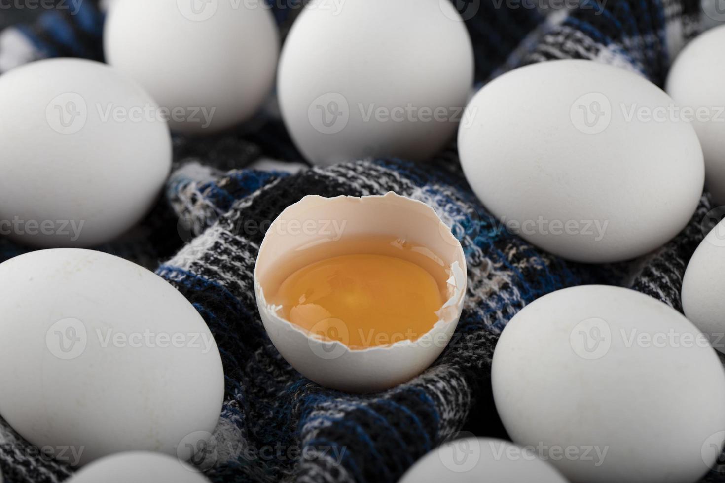 jaune d'oeuf et oeufs blancs sur un tissu rayé photo