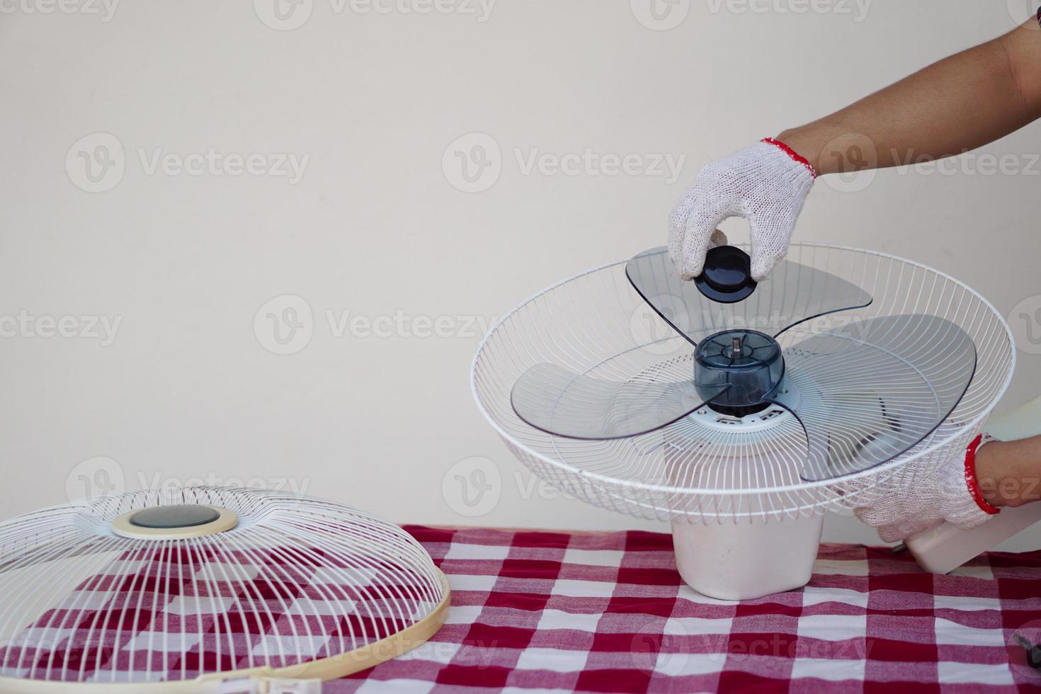 fermer mécanicien mains combiner partie de électrique ventilateur. concept, entretien appareil, électrique dispositifs dans du quotidien vie, vérifier ,réparation ou réparer lorsque il a problèmes pour longue en utilisant. photo