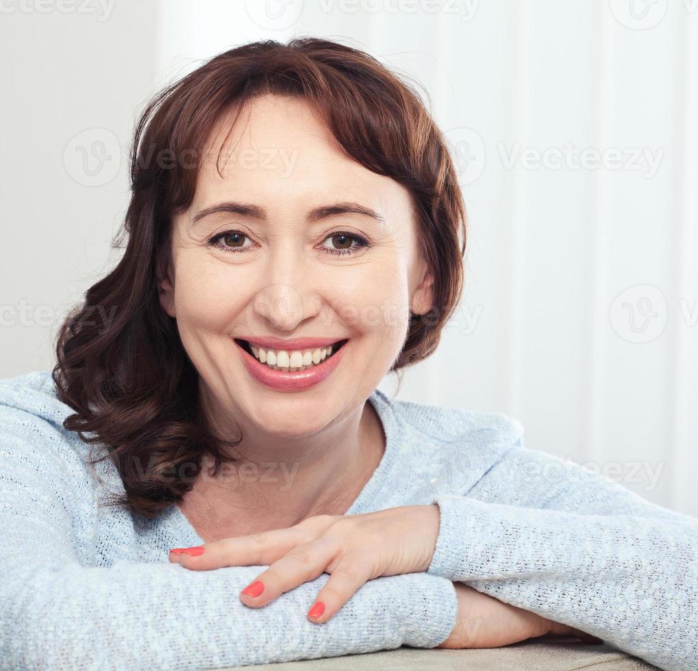 charmant âge moyen brunette femme avec une radieux sourire séance o photo