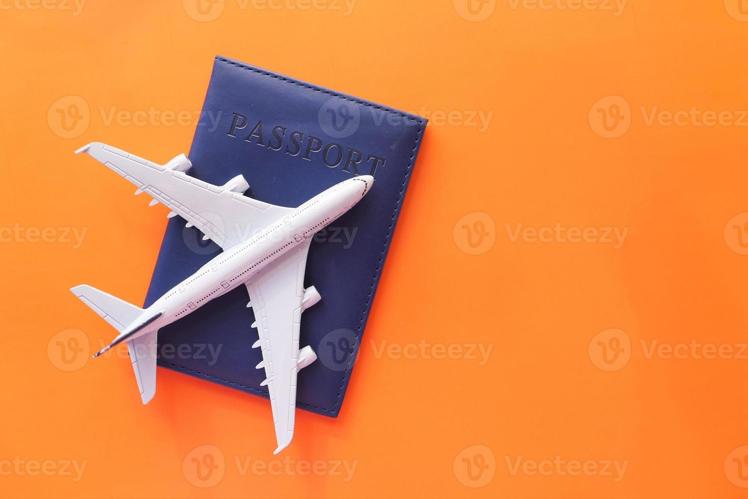 concept de vacances de voyage avec avion et passeport sur fond orange photo