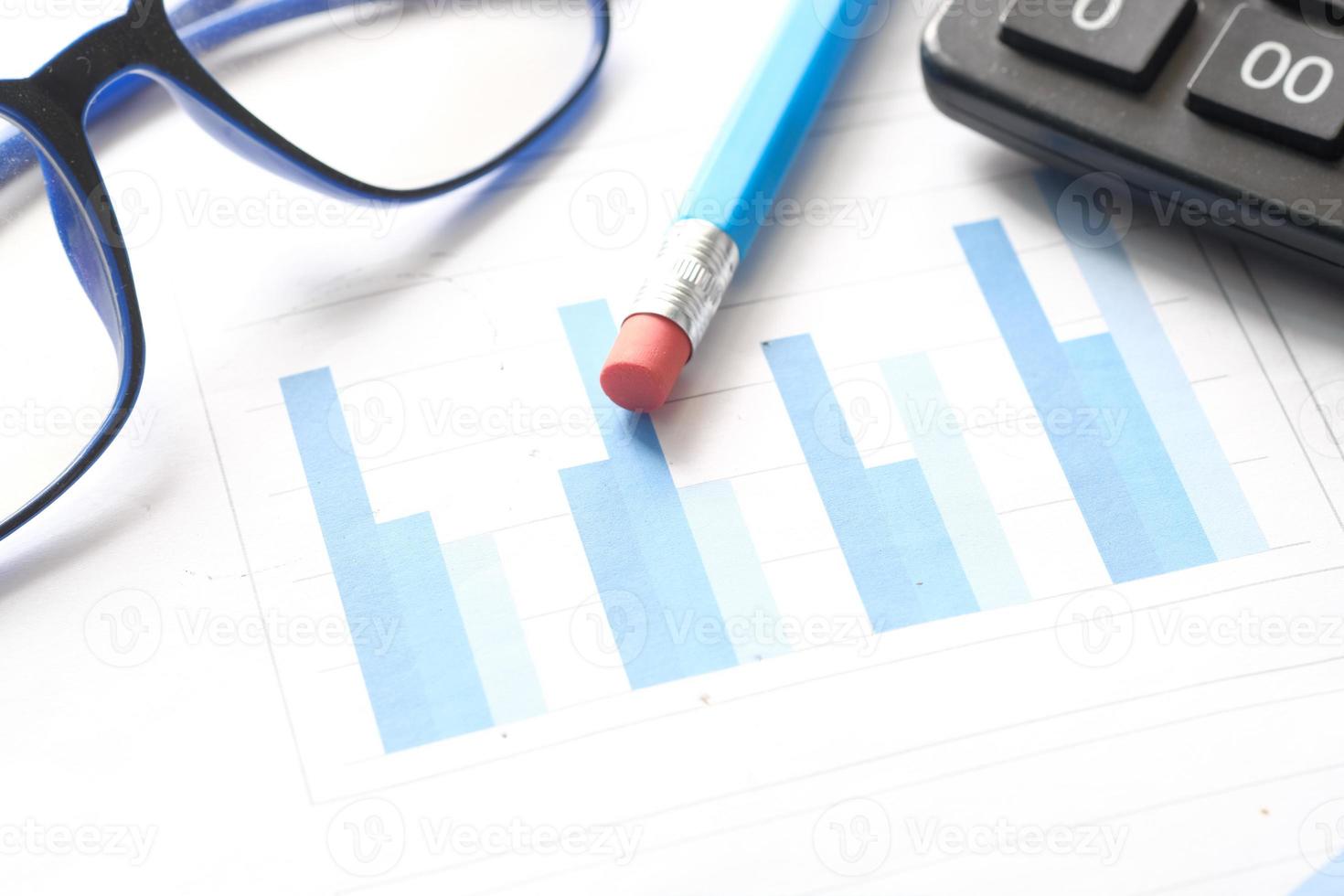 graphique financier, calculatrice et bloc-notes sur table photo