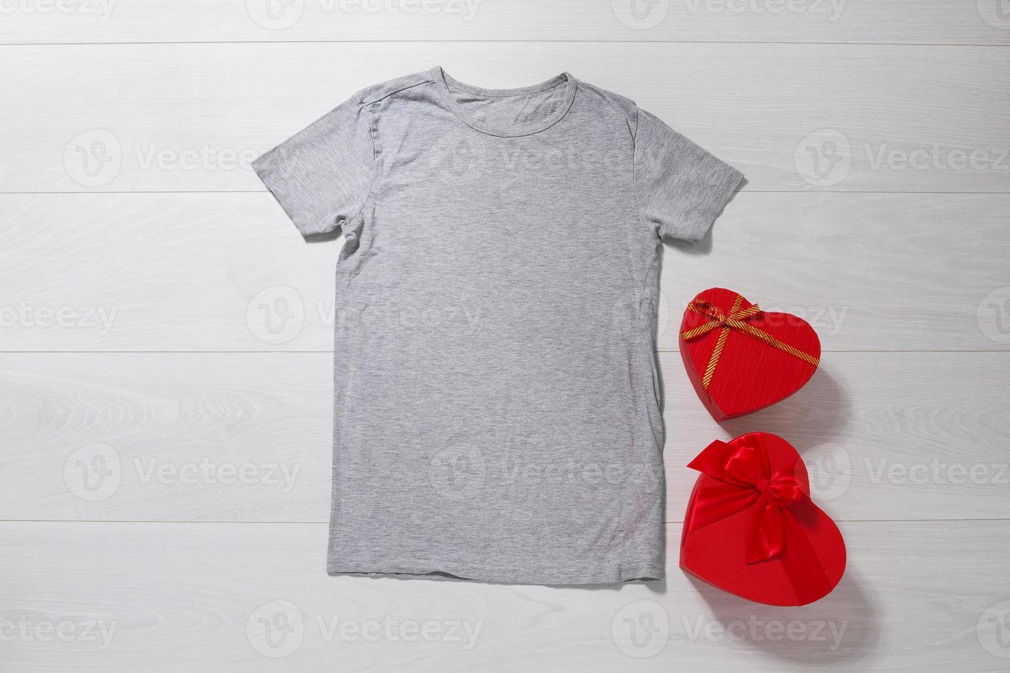 gris T-shirt maquette. valentines journée concept chemise, cadeau des boites cœur forme sur en bois Contexte. copie espace, modèle Vide de face vue T-shirt vêtements. romantique tenue. plat allonger vacances mode photo