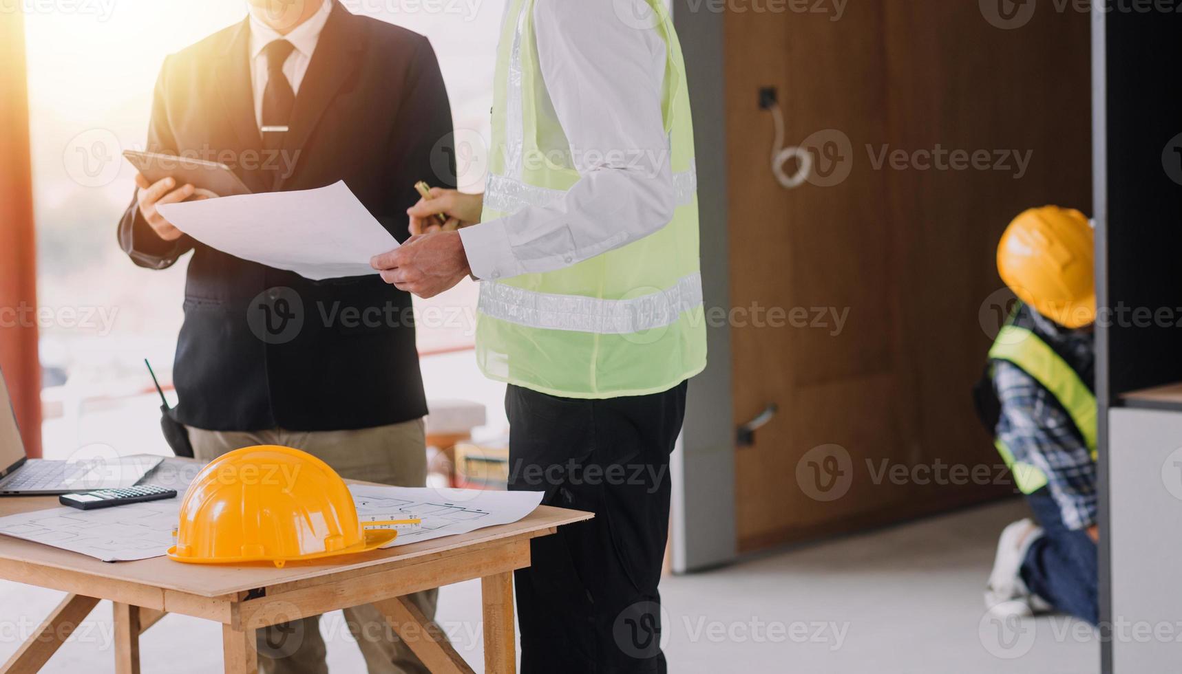 diverse équipe de spécialistes utilisation tablette ordinateur sur construction placer. réel biens bâtiment projet avec civil ingénieur, architecte, affaires investisseur et général ouvrier discuter plan détails. photo