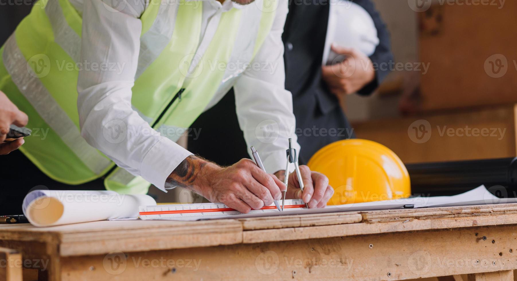 diverse équipe de spécialistes utilisation tablette ordinateur sur construction placer. réel biens bâtiment projet avec civil ingénieur, architecte, affaires investisseur et général ouvrier discuter plan détails. photo