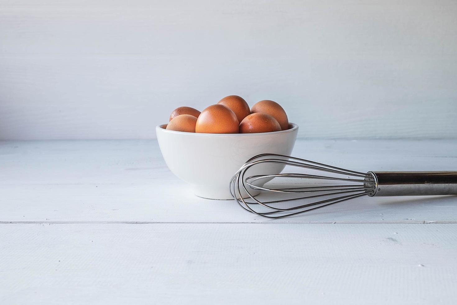 oeufs dans un bol avec un fouet photo