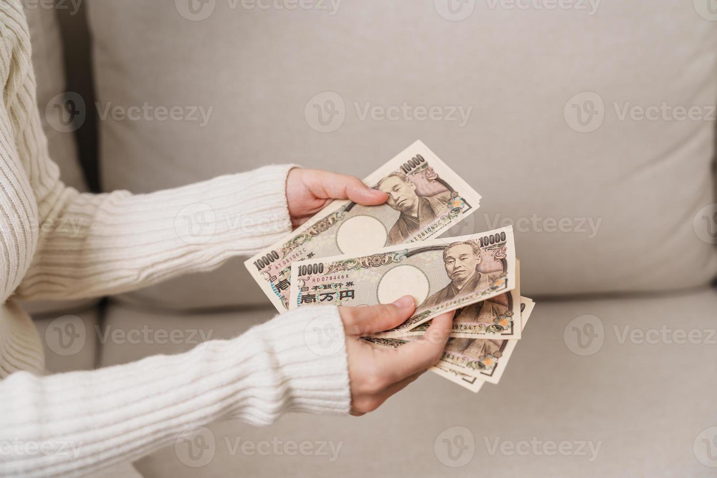 main de femme tenant la pile de billets de banque en yen japonais. mille yens d'argent. trésorerie du japon, impôt, économie de récession, inflation, investissement, finances et concepts de paiement d'achat photo