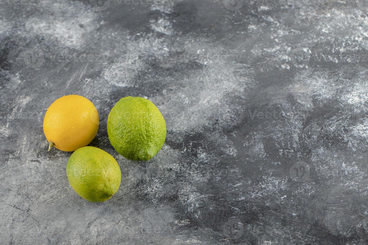 Citrons jaunes et verts sur fond de marbre photo