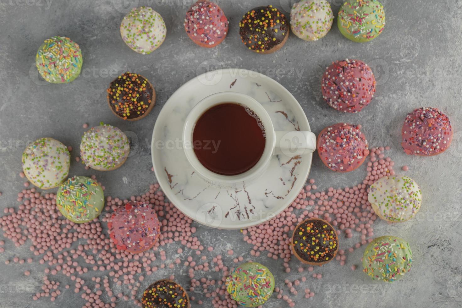 beignets sucrés colorés avec une tasse de thé photo