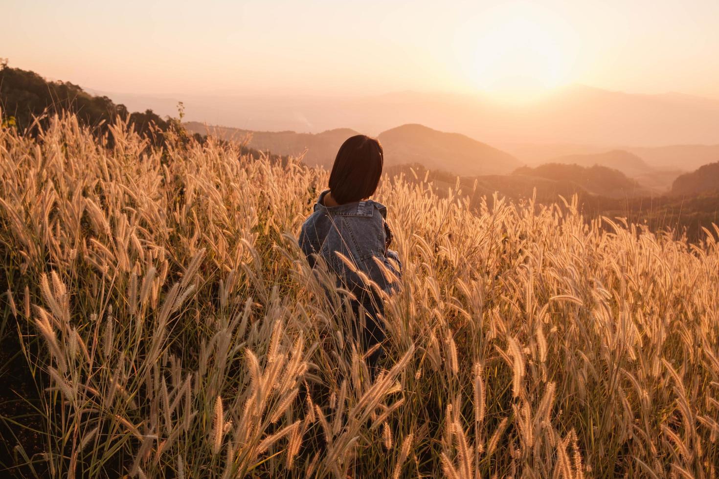 femme dans un pré au coucher du soleil photo