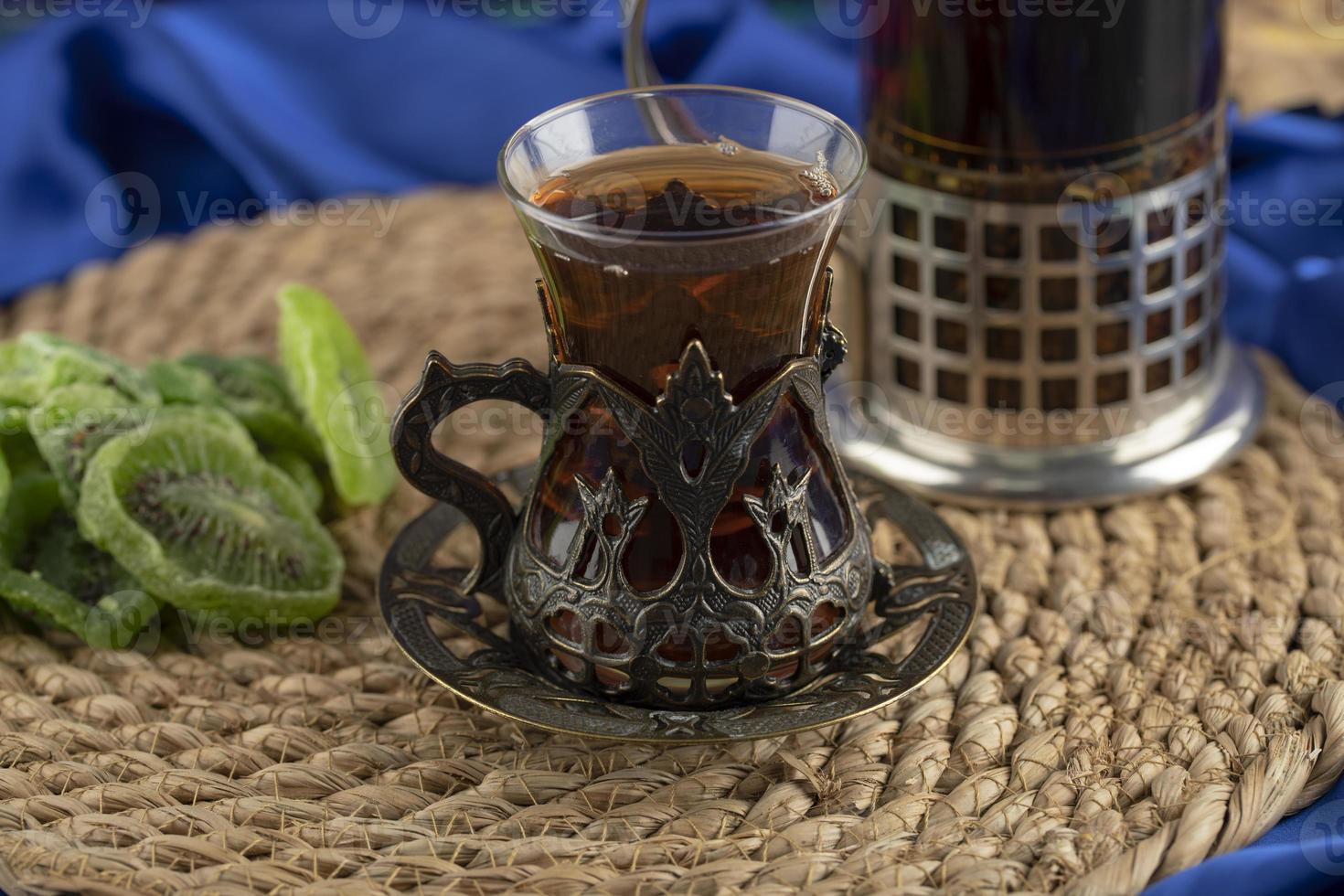 Une tasse en verre avec des kiwis séchés sur un fond clair photo